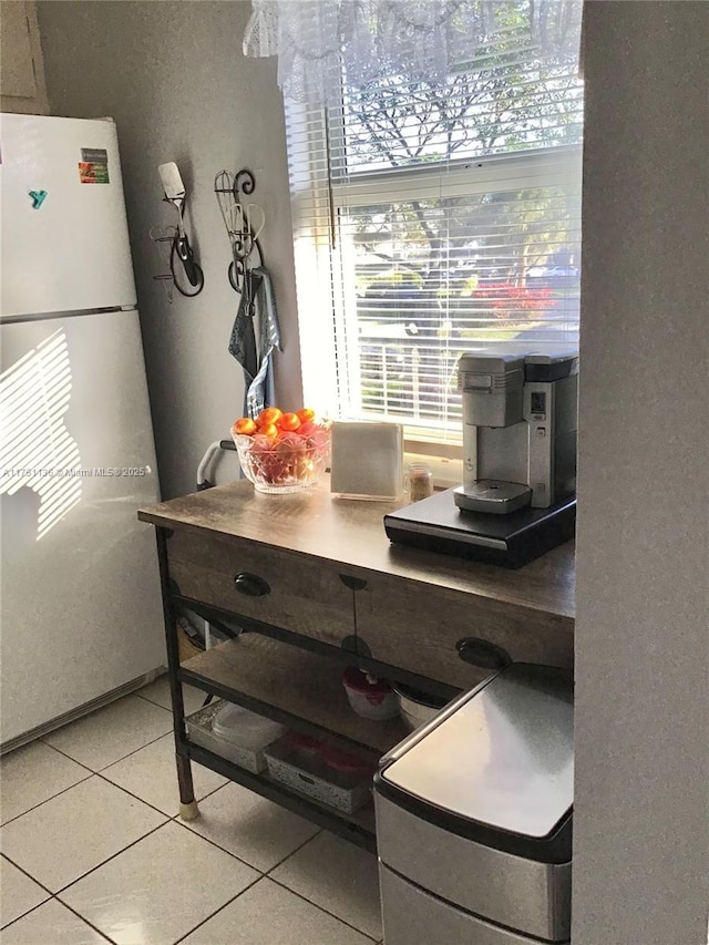 kitchen featuring light tile patterned floors and freestanding refrigerator