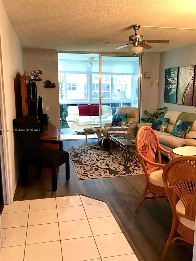 living area featuring a textured ceiling, wood finished floors, and a ceiling fan