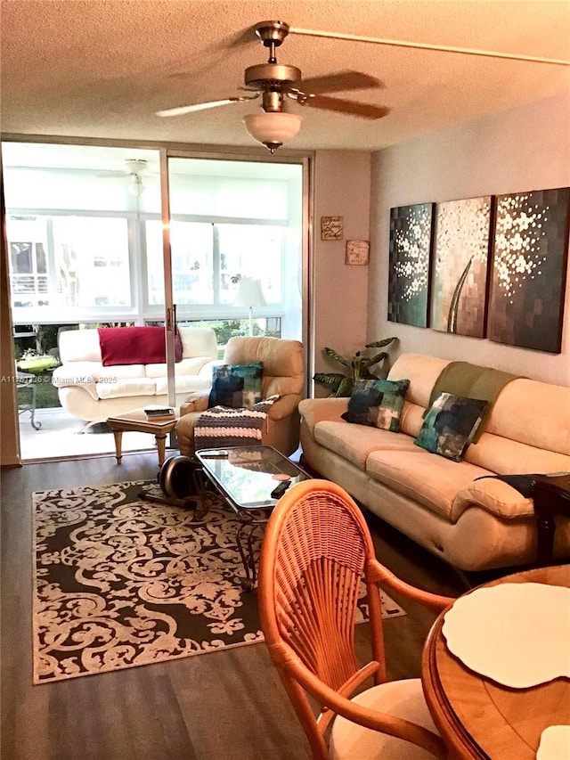 living room featuring ceiling fan, a textured ceiling, and wood finished floors