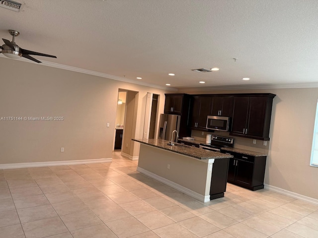 kitchen featuring a sink, visible vents, appliances with stainless steel finishes, dark stone counters, and a center island with sink