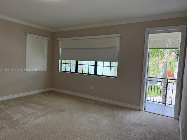 spare room with baseboards, ornamental molding, plenty of natural light, and light colored carpet