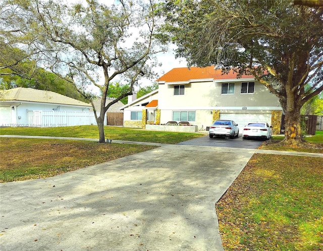 view of front of home featuring an attached garage, driveway, a front yard, and stucco siding