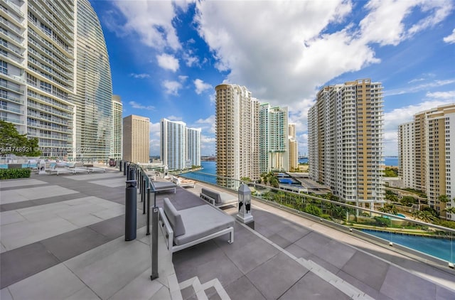 view of patio with a water view and a view of city