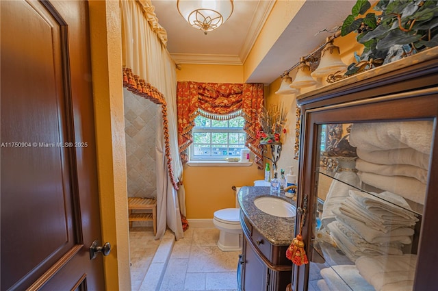1111 Washington St, Hollywood, FL 33019 - bathroom with crown molding, stone tile flooring, toilet, vanity, and baseboards