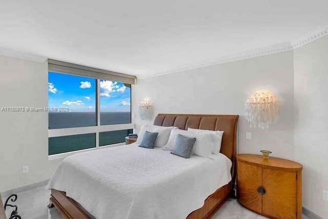 bedroom with a water view, baseboards, and light colored carpet