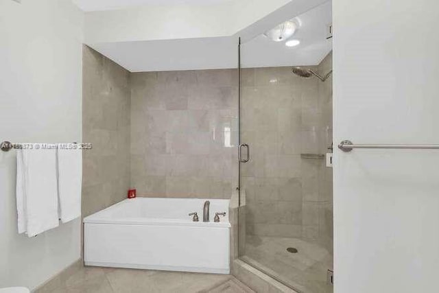 full bath with a stall shower, a bath, and tile patterned floors