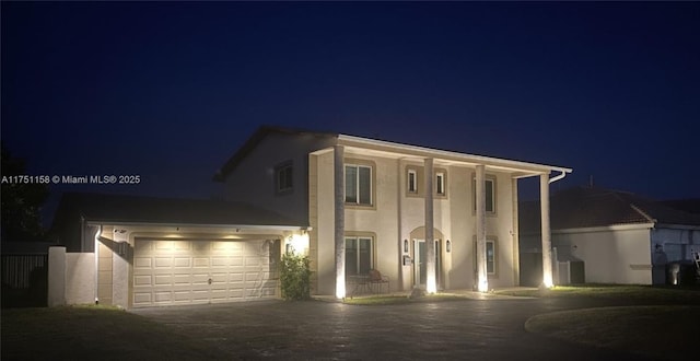 neoclassical / greek revival house with driveway and stucco siding