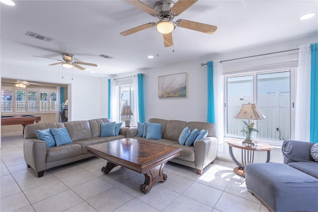 living room with light tile patterned floors, visible vents, and a healthy amount of sunlight