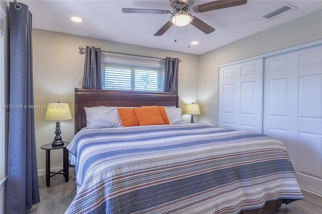 bedroom with recessed lighting, wood finished floors, visible vents, a ceiling fan, and a closet