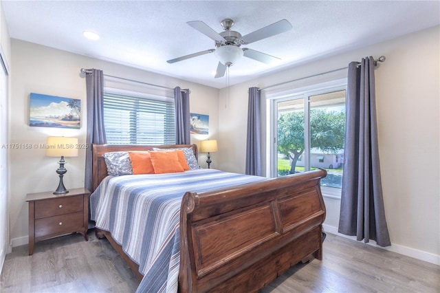 bedroom featuring baseboards, a ceiling fan, and light wood-style floors