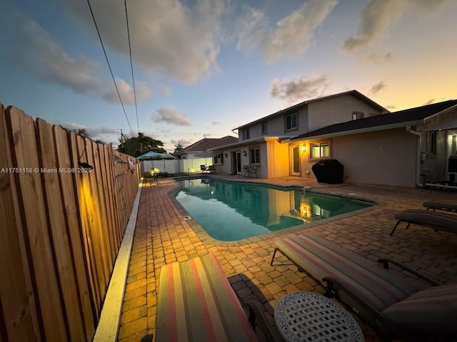 view of pool featuring a fenced in pool, a patio area, a fenced backyard, and area for grilling