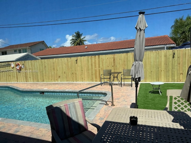 view of swimming pool featuring a fenced in pool, fence, and a patio