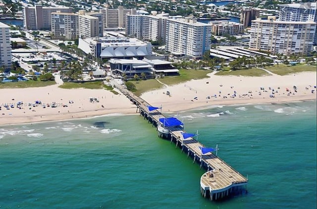 birds eye view of property featuring a view of city, a beach view, and a water view