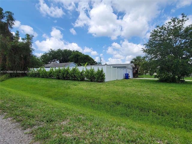 view of yard featuring a garage and fence