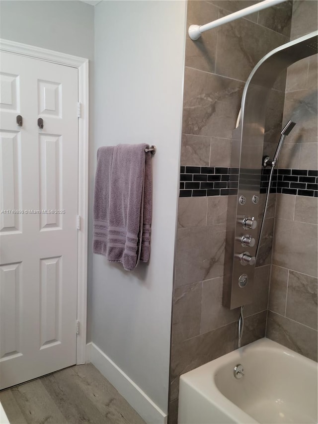 bathroom featuring shower / washtub combination and baseboards