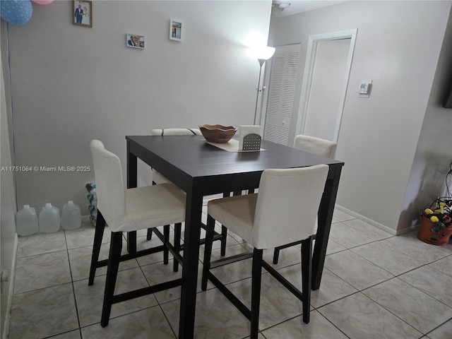 dining area with baseboards and light tile patterned flooring