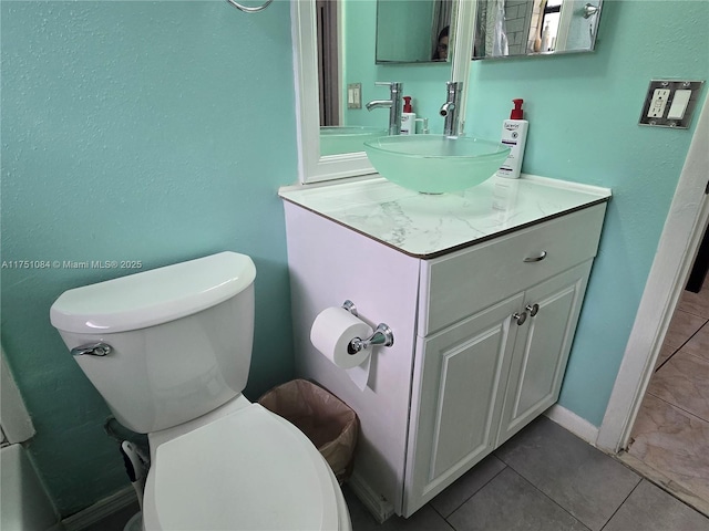 bathroom with baseboards, vanity, toilet, and tile patterned floors