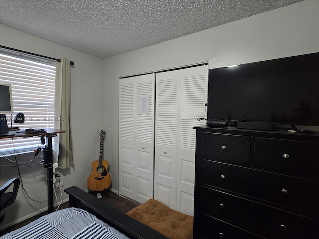 bedroom with a closet, a textured ceiling, and baseboards