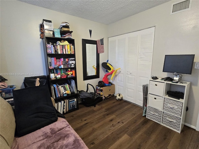 interior space featuring a textured ceiling, visible vents, and dark wood-type flooring