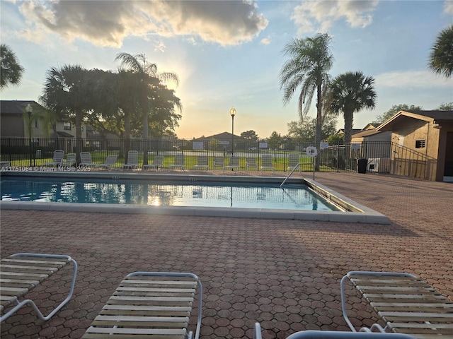 community pool with fence and a patio