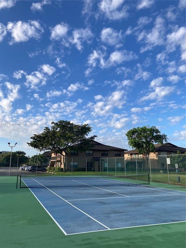 view of tennis court featuring fence