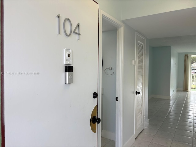 hall featuring baseboards and tile patterned floors