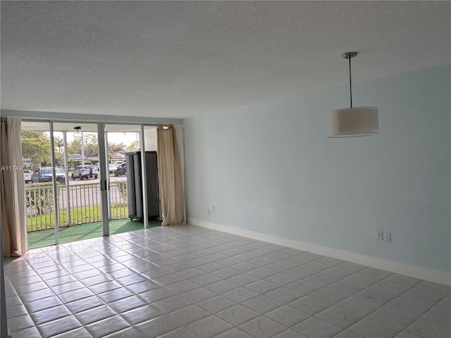 unfurnished room with a textured ceiling, baseboards, and light tile patterned floors