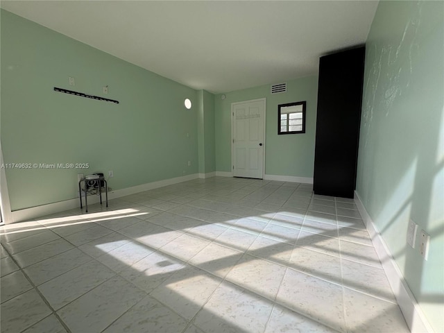 unfurnished room with visible vents and baseboards