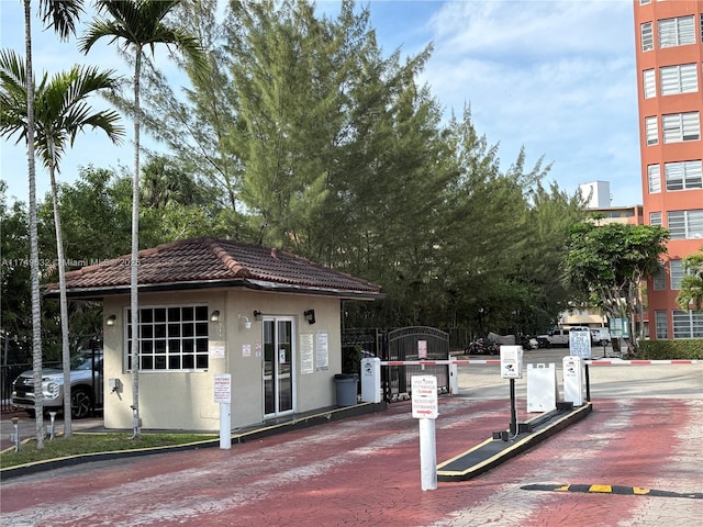 exterior space with a tiled roof, a gate, and stucco siding