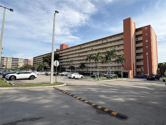 view of building exterior featuring uncovered parking and a city view