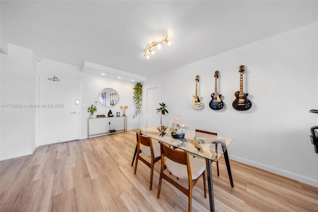 dining area featuring light wood-style floors and baseboards