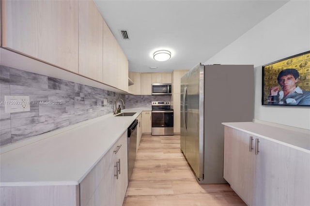 kitchen featuring a sink, visible vents, light countertops, appliances with stainless steel finishes, and modern cabinets