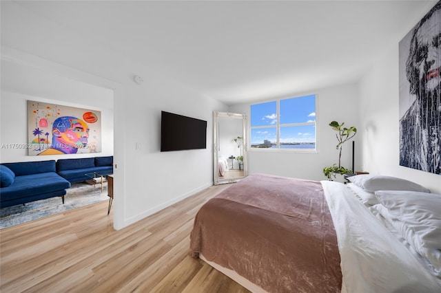 bedroom featuring light wood-style floors and baseboards