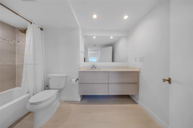 bathroom with toilet, baseboards, shower / bath combination with curtain, and vanity