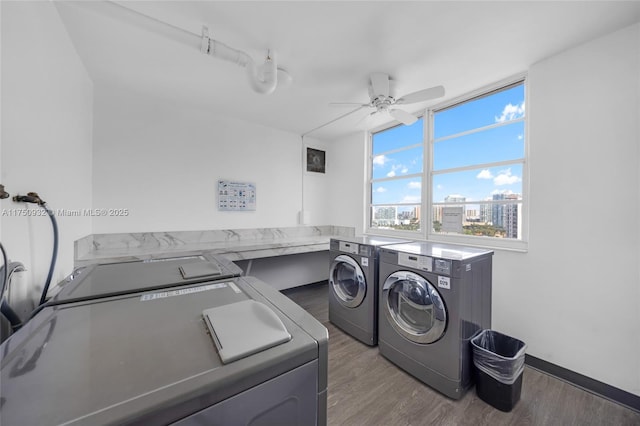 washroom featuring laundry area, dark wood-type flooring, washing machine and dryer, and a city view