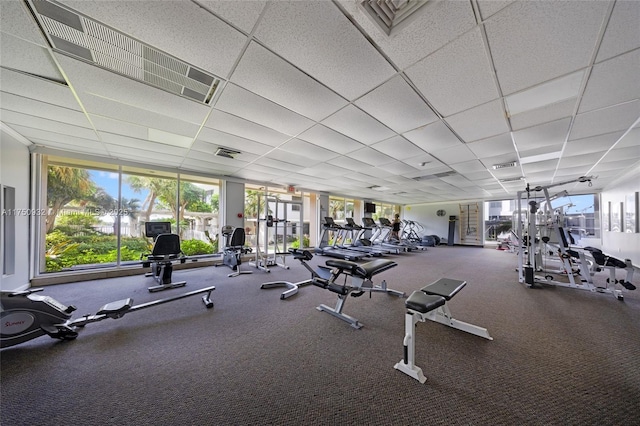 gym with a paneled ceiling and visible vents