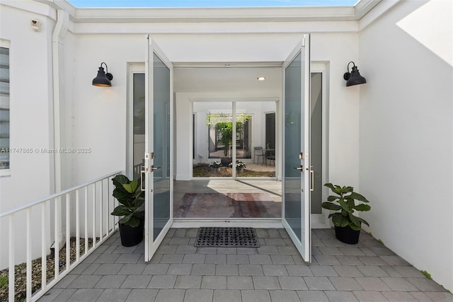 view of exterior entry with french doors and stucco siding