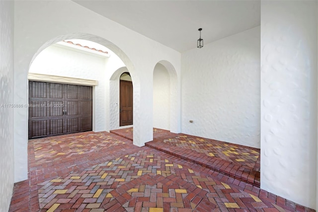 empty room with brick floor and arched walkways