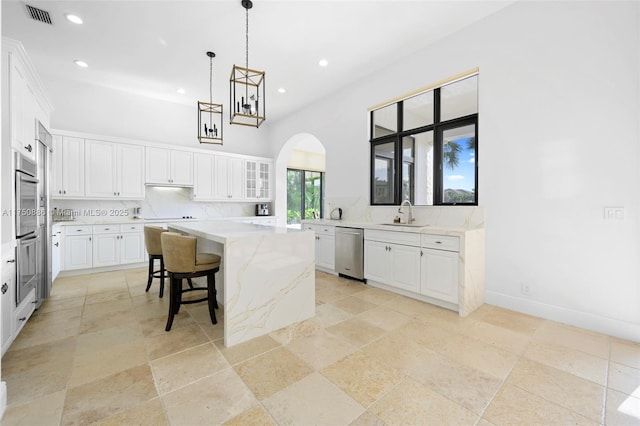 kitchen featuring visible vents, stainless steel appliances, decorative backsplash, and a center island