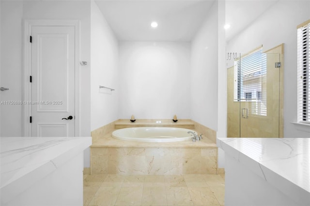 full bath featuring a stall shower, a garden tub, and recessed lighting