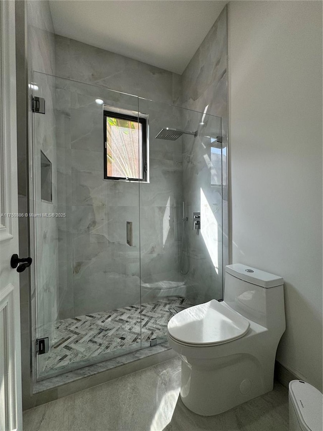 bathroom with marble finish floor, a marble finish shower, and toilet