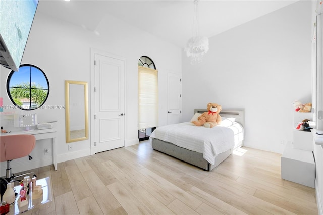 bedroom featuring a chandelier and wood finished floors