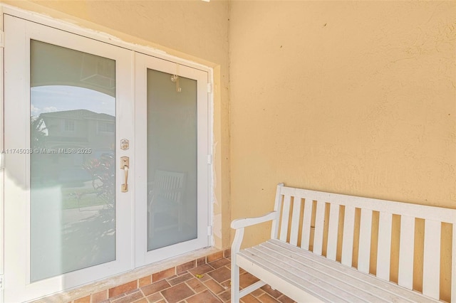 entrance to property featuring french doors, a patio area, and stucco siding