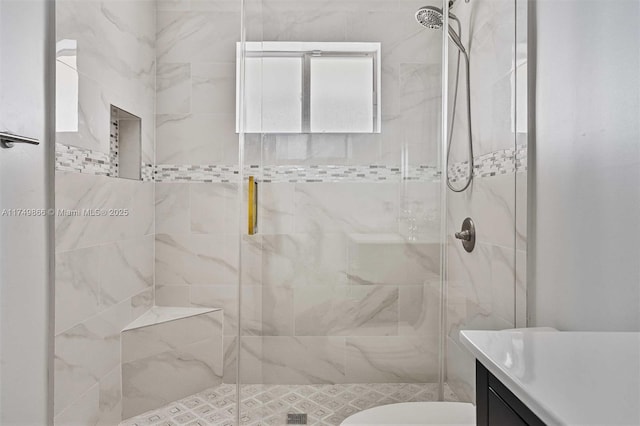 bathroom with a stall shower, vanity, and toilet