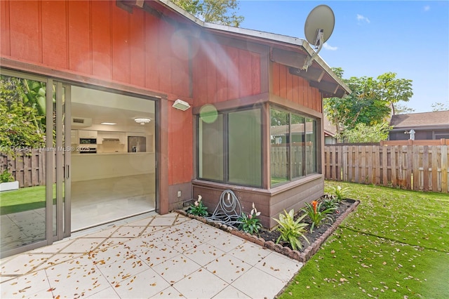 doorway to property with fence and a yard