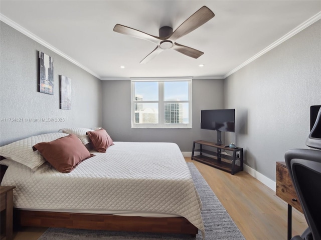 bedroom with a ceiling fan, baseboards, ornamental molding, light wood-style floors, and a textured wall