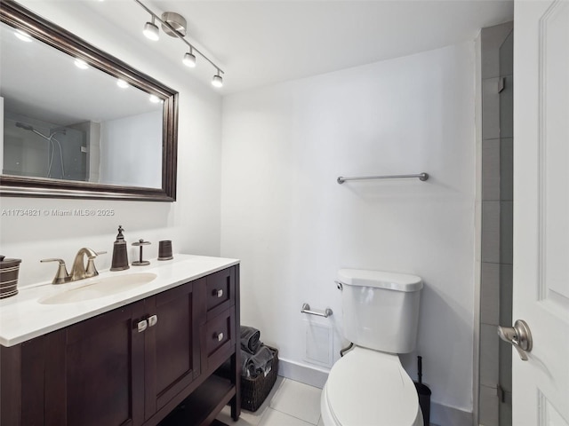 bathroom with tile patterned flooring, track lighting, toilet, and vanity