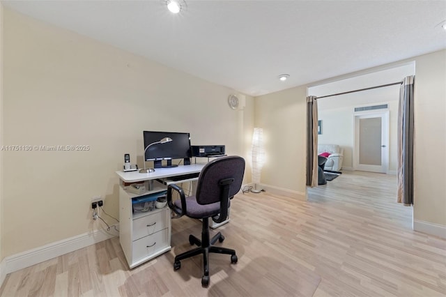 home office featuring light wood-type flooring and baseboards