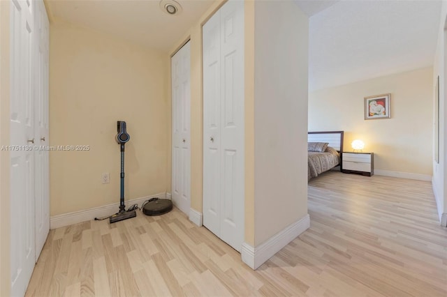 hallway featuring baseboards and light wood-style floors