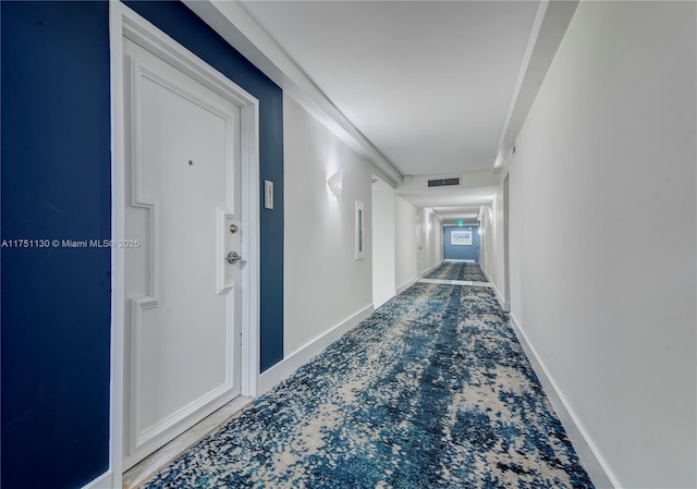 corridor featuring carpet flooring, visible vents, and baseboards